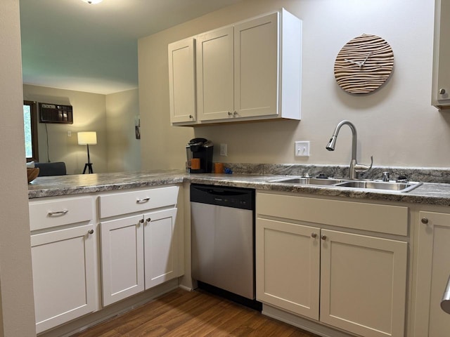 kitchen with stainless steel dishwasher, a sink, dark wood finished floors, white cabinetry, and a peninsula