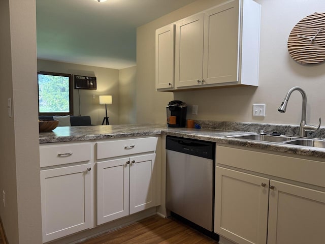 kitchen featuring stainless steel dishwasher, a sink, dark wood-style flooring, and white cabinetry