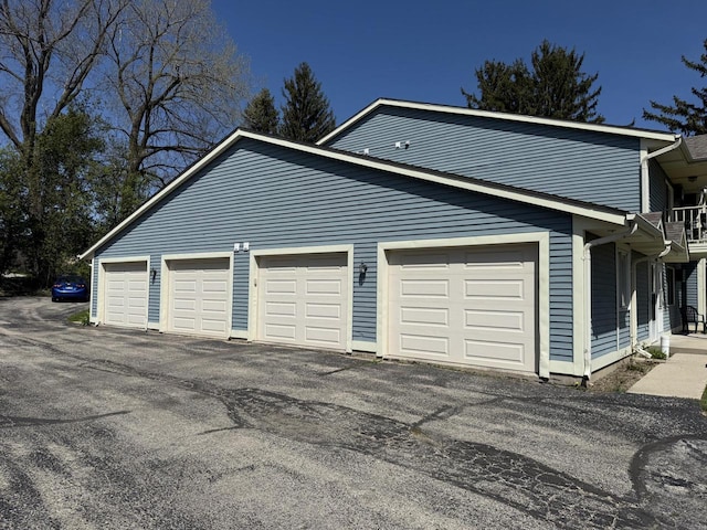 garage featuring asphalt driveway