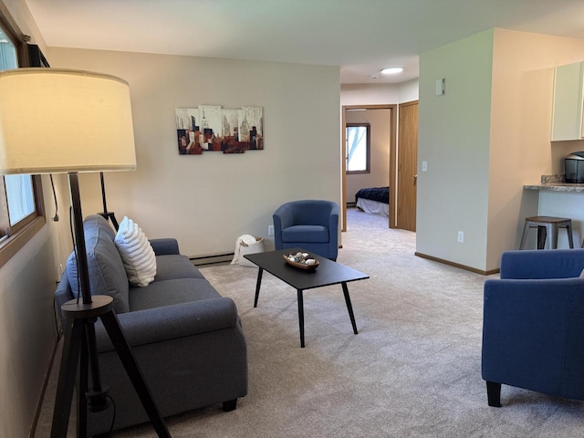 living area featuring light colored carpet, a baseboard radiator, and baseboards