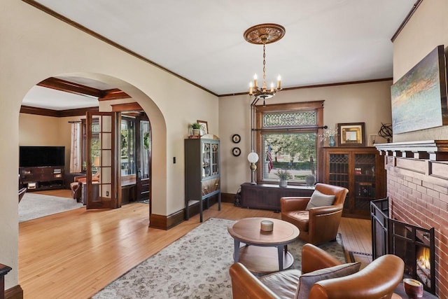 350 Madison St, Wisconsin Rapids, WI 54494 - living area with a fireplace, arched walkways, ornamental molding, wood finished floors, and a chandelier