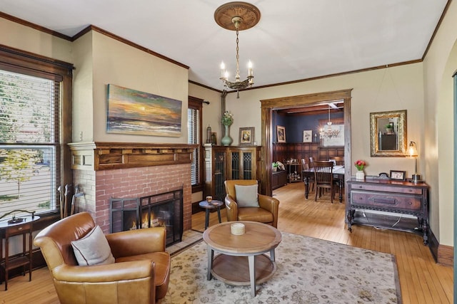 350 Madison St, Wisconsin Rapids, WI 54494 - living area with a chandelier, crown molding, light wood finished floors, and a brick fireplace