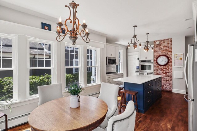 350 Madison St, Wisconsin Rapids, WI 54494 - dining area with a chandelier, a baseboard heating unit, dark wood-style floors, and baseboards