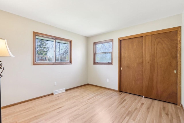 1445 17th Ave, Grafton, WI 53024 - unfurnished bedroom with light wood-style floors, a closet, and baseboards