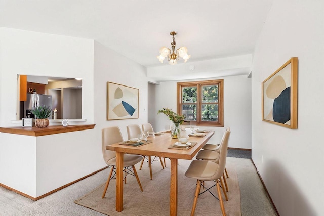 1445 17th Ave, Grafton, WI 53024 - dining area featuring light colored carpet, baseboards, and a chandelier