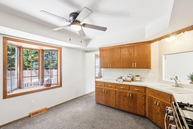 1445 17th Ave, Grafton, WI 53024 - kitchen with a sink, carpet, light countertops, ceiling fan, and brown cabinets