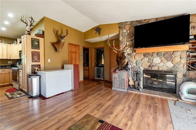 N3751 Bryant Rd, Bruce, WI 54819 - kitchen featuring refrigerator, light wood-type flooring, lofted ceiling, dark countertops, and stove