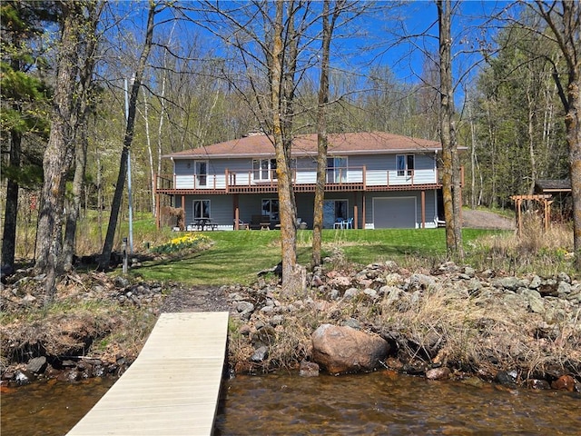 23075 Missionary Point Dr, Cable, WI 54821 - rear view of house with an attached garage, a lawn, and a deck