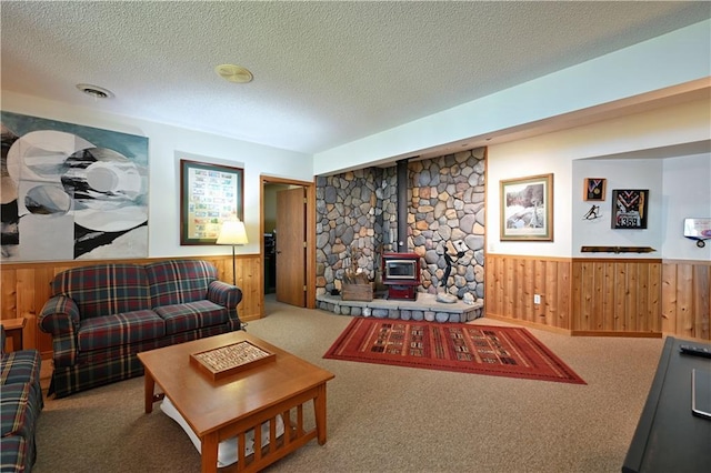 23075 Missionary Point Dr, Cable, WI 54821 - living area with a wood stove, wainscoting, carpet floors, a textured ceiling, and wooden walls