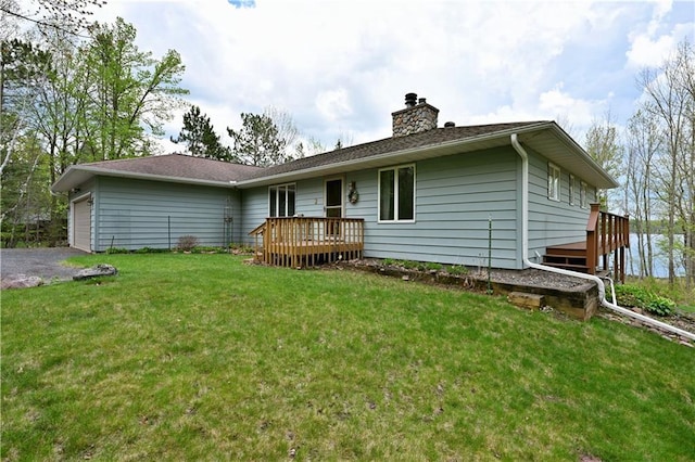 23075 Missionary Point Dr, Cable, WI 54821 - back of property featuring a deck, a lawn, a chimney, a garage, and asphalt driveway