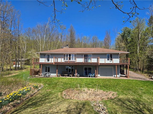 23075 Missionary Point Dr, Cable, WI 54821 - rear view of house with a wooden deck, a yard, an attached garage, and a patio area