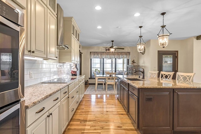 335 Bella Way, Sun Prairie, WI 53590 - kitchen featuring a sink, appliances with stainless steel finishes, light wood finished floors, cream cabinetry, and recessed lighting