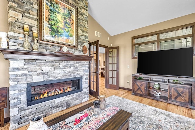 335 Bella Way, Sun Prairie, WI 53590 - living area with wood finished floors, a fireplace, baseboards, high vaulted ceiling, and french doors