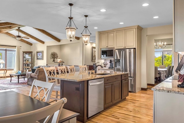 335 Bella Way, Sun Prairie, WI 53590 - kitchen with a chandelier, stainless steel appliances, a sink, light wood-style floors, and cream cabinets