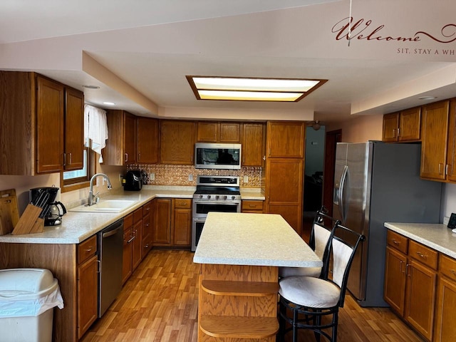 N9960 Meadowlark Ln, Crivitz, WI 54114 - kitchen featuring appliances with stainless steel finishes, a sink, light countertops, light wood-type flooring, and a center island