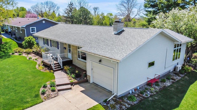 308 Maple Dr, Mount Horeb, WI 53572 - view of front of house featuring a chimney, a front yard, a garage, driveway, and roof with shingles