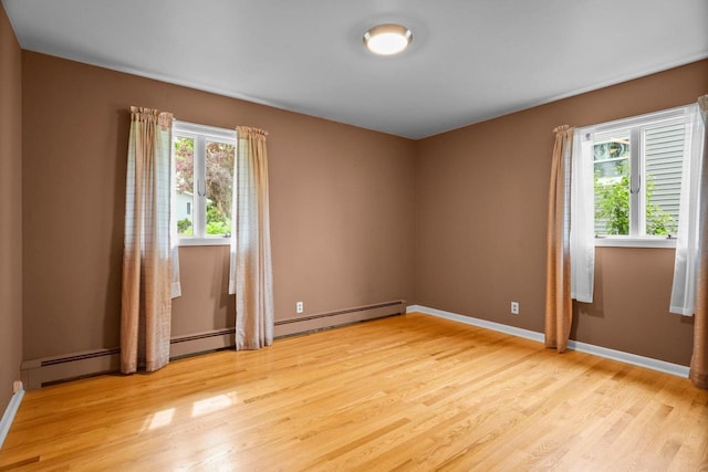 308 Maple Dr, Mount Horeb, WI 53572 - empty room featuring light wood-style flooring, baseboards, and a baseboard heating unit