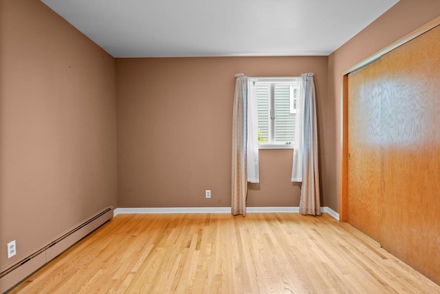 308 Maple Dr, Mount Horeb, WI 53572 - spare room featuring baseboard heating, light wood-type flooring, and baseboards