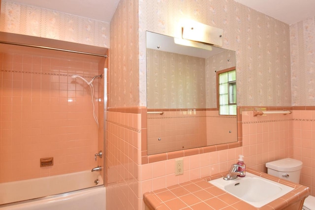 15060 Carpenter Rd, Brookfield, WI 53005 - bathroom featuring wallpapered walls, toilet, shower / washtub combination, a wainscoted wall, and tile walls