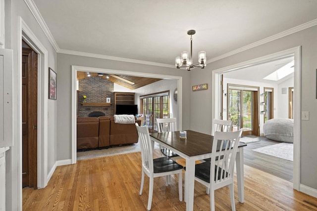 918 E Kramer Ln, Appleton, WI 54915 - dining space with a fireplace, a chandelier, light wood-style flooring, crown molding, and baseboards