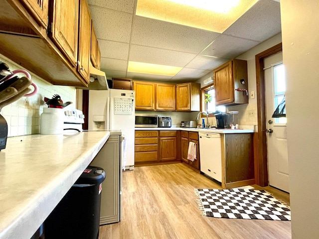 108 S Center St, Orfordville, WI 53576 - kitchen featuring white appliances, light wood-style floors, light countertops, brown cabinetry, and a paneled ceiling