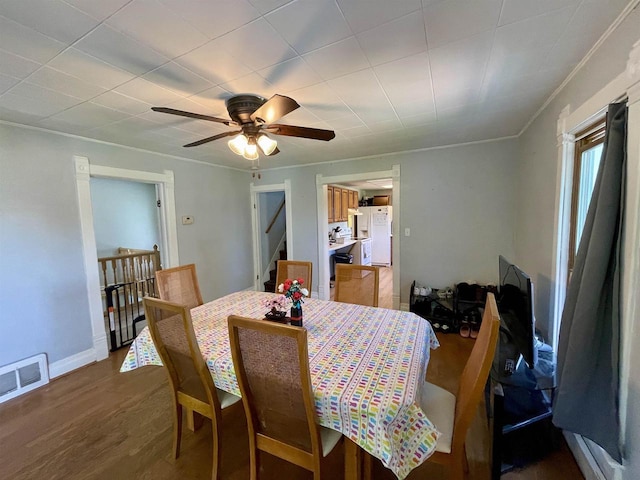 108 S Center St, Orfordville, WI 53576 - dining room with ceiling fan, wood finished floors, crown molding, stairs, and baseboards
