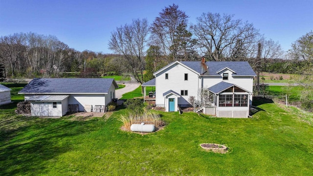 N4618 State Road 49, Waupaca, WI 54981 - back of house with a sunroom, an outbuilding, a yard, and a chimney