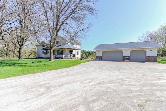 N4618 State Road 49, Waupaca, WI 54981 - view of front facade featuring brick siding, a porch, driveway, a front yard, and an outbuilding
