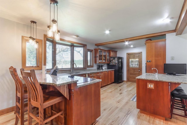 N4618 State Road 49, Waupaca, WI 54981 - kitchen featuring a sink, brown cabinets, a peninsula, and freestanding refrigerator