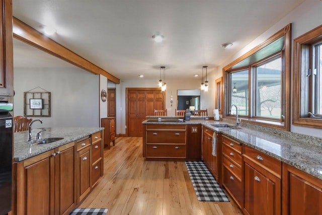 N4618 State Road 49, Waupaca, WI 54981 - kitchen with a sink, brown cabinets, light wood-type flooring, and a peninsula