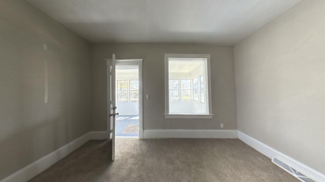 carpeted spare room with baseboards