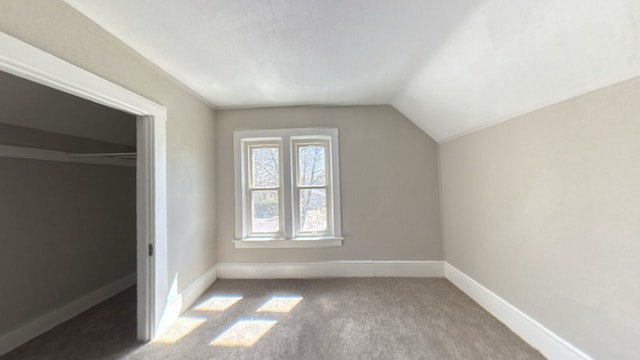additional living space featuring vaulted ceiling, baseboards, and carpet flooring