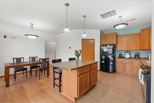 1119 Enterprise Dr, Verona, WI 53593 - kitchen featuring black appliances, a kitchen island, pendant lighting, a breakfast bar, and brown cabinets