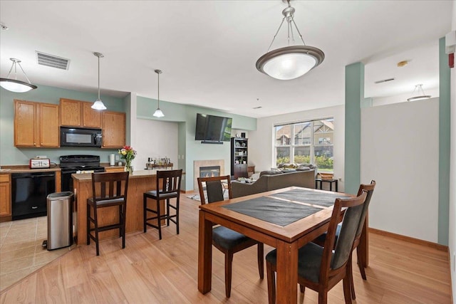 1119 Enterprise Dr, Verona, WI 53593 - dining space featuring light wood-style flooring and a glass covered fireplace