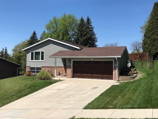 1528 Jefferson St, West Bend, WI 53090 - tri-level home with brick siding, a garage, and concrete driveway