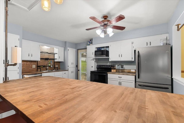 1528 Jefferson St, West Bend, WI 53090 - kitchen featuring appliances with stainless steel finishes, a sink, wooden counters, ceiling fan, and backsplash