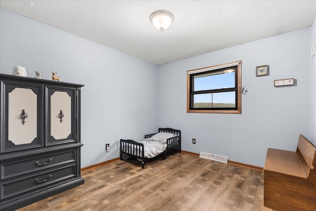 1528 Jefferson St, West Bend, WI 53090 - bedroom with wood finished floors, baseboards, and a nursery area