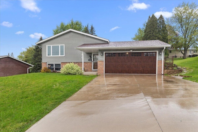 1528 Jefferson St, West Bend, WI 53090 - split level home featuring concrete driveway, a garage, a front lawn, and brick siding