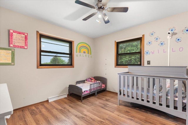 1528 Jefferson St, West Bend, WI 53090 - bedroom with multiple windows, wood finished floors, a nursery area, and baseboards