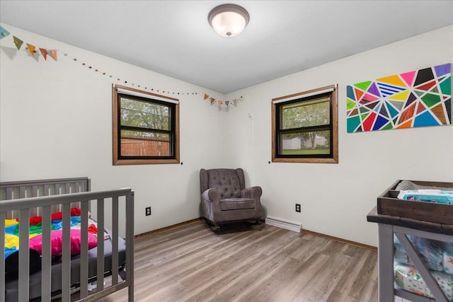 1528 Jefferson St, West Bend, WI 53090 - bedroom featuring wood finished floors, a nursery area, and baseboards