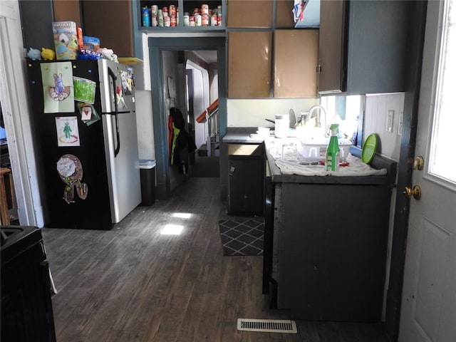 818 W Main St, Augusta, WI 54722 - kitchen with freestanding refrigerator, dark wood finished floors, black / electric stove, and a sink