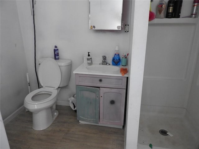 818 W Main St, Augusta, WI 54722 - bathroom with toilet, vanity, wood finished floors, baseboards, and a shower