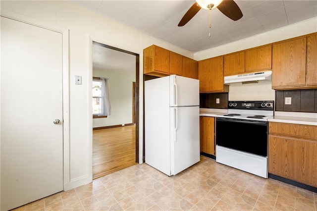 kitchen featuring freestanding refrigerator, electric stove, under cabinet range hood, brown cabinetry, and ceiling fan