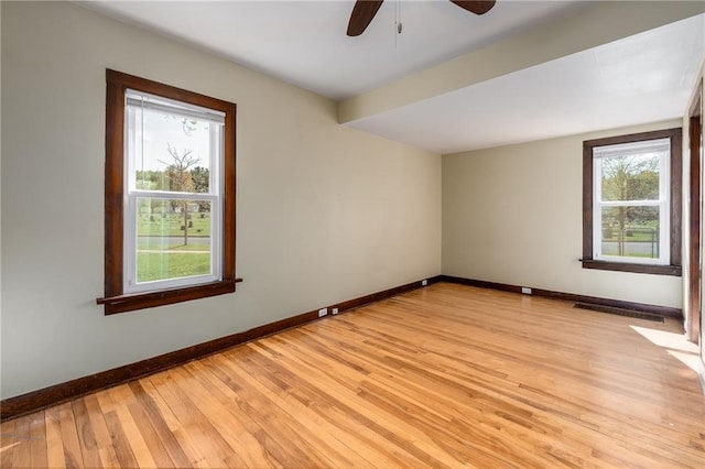 empty room with light wood-type flooring, baseboards, and a ceiling fan