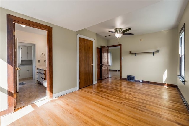 unfurnished room featuring light wood-style flooring, baseboards, and ceiling fan