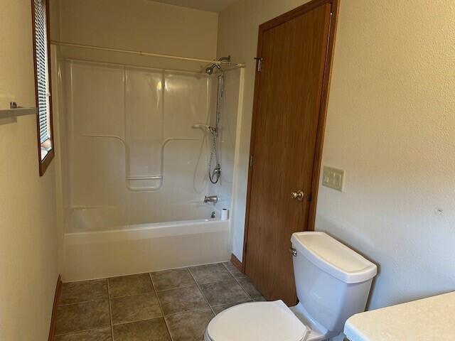 1521 Raveen St, Fort Atkinson, WI 53538 - full bathroom featuring toilet,  shower combination, and tile patterned floors