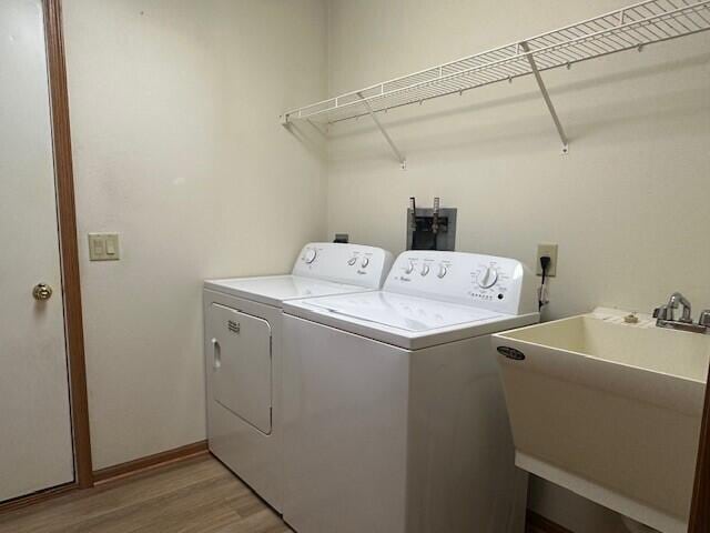 1521 Raveen St, Fort Atkinson, WI 53538 - laundry area featuring washing machine and clothes dryer, light wood-style floors, and baseboards
