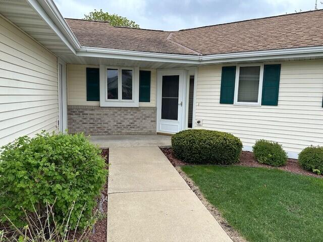 1521 Raveen St, Fort Atkinson, WI 53538 - view of exterior entry featuring a shingled roof and brick siding