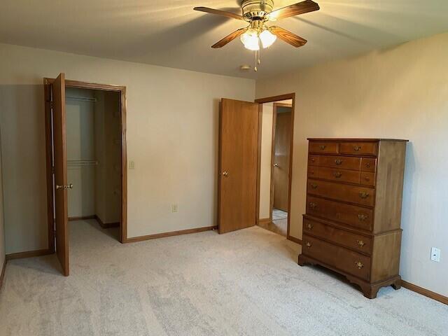 1521 Raveen St, Fort Atkinson, WI 53538 - bedroom featuring light carpet, baseboards, a ceiling fan, and a closet
