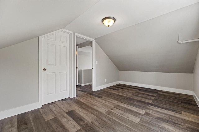 additional living space with baseboards, lofted ceiling, and wood finished floors